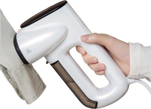 Neakasa handheld clothes steamer shown in use, providing fast and consistent steam to remove wrinkles from shirts, blouses, and everyday garments. The compact and lightweight design makes it suitable for home use or travel, while the 1800W heating system delivers quick warm-up and strong steam flow. The 280ml water tank offers several minutes of continuous steaming for multiple clothing pieces. This steamer works well on cotton, linen, silk, wool, and synthetic fabrics, making it a versatile solution for qu